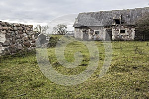 Late autumn. An old abandoned barn, cellar and granite wall .