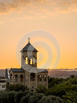 Late evening bright sunset sun rays enlighten through the small chapel arches near the Holy Trinity Cathedral of Tbilisi, Georgia