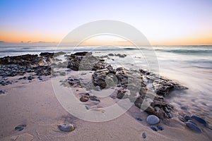 Late evening landscape of ocean over rocky shore with clouds blowing