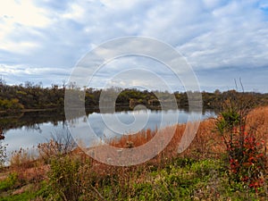Late fall landscape scene with autumn colors still showing on calm lake