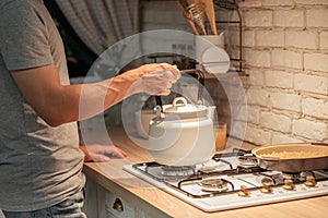 Late night tea habit man putting kettle stove