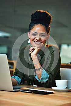 Late nights in the office are nothing for me. Portrait of an attractive young woman working on her laptop in the office.