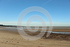 Late summer strolling over the sands on the beaches of Whitstable, Kent, UK taking in the sights and patterns in the sand made by