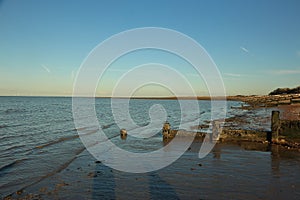 Late summer strolling over the sands on the beaches of Whitstable, Kent, UK taking in the sights and patterns in the sand made by