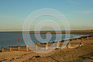 Late summer strolling over the sands on the beaches of Whitstable, Kent, UK taking in the sights and patterns in the sand made by