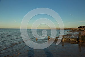 Late summer strolling over the sands on the beaches of Whitstable, Kent, UK taking in the sights and patterns in the sand made by