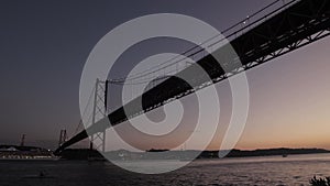 Late sunset landscape of a big ship sailing under the bridge