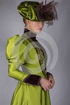 Late Victorian woman in green silk ensemble