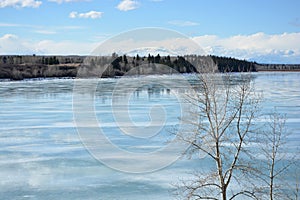 Late-winter landscape of reflection on icy lake