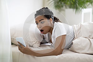 Late For Work. Shocked Overslept Black Woman Looking At Smartphone In Hand