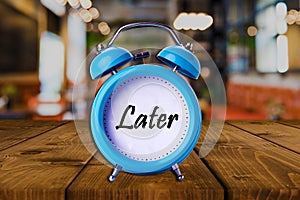 Later text on Alarm Clock on wooden table.