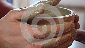 Lateral close up of ceramist`s hands shaping a vase FDV