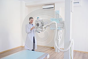 lateral view of a male radiologist adjusting the X-ray machine