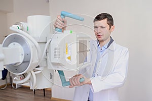 lateral view of a male radiologist adjusting the X-ray machine