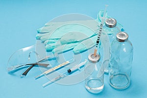 Latex gloves, a glasses, syringes and bottles for liquid medicine
