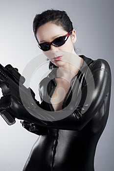 Latex jumpsuit, young lady with gun