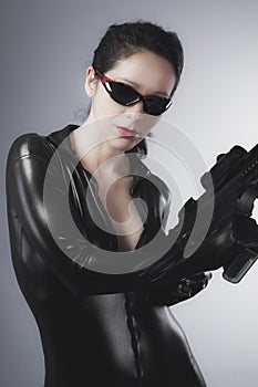 Latex jumpsuit, young lady with gun