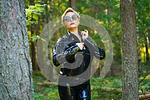 Latex rubber fashion woman walking in the forest
