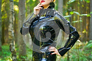 Latex rubber fashion woman walking in the forest