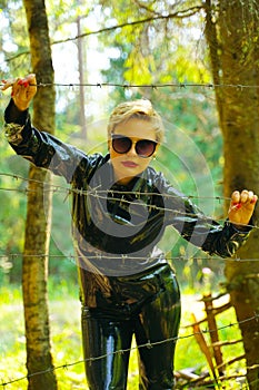 Latex rubber fashion woman walking in the forest