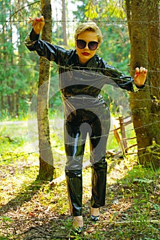 Latex rubber fashion woman walking in the forest