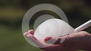 Lather and tubing to create bubbles in the palm of womanâ€™s hand