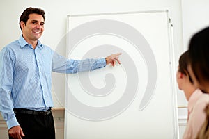 Latin adult businessman pointing at whiteboard