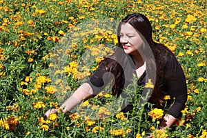 Latin adult woman in field of yellow flowers, day of the dead flower in Cholula Puebla Mexico