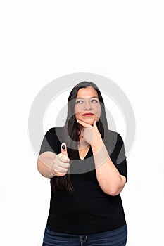 Latin adult woman shows her thumb inked with indelible electoral ink after exercising her right to free and secret voting