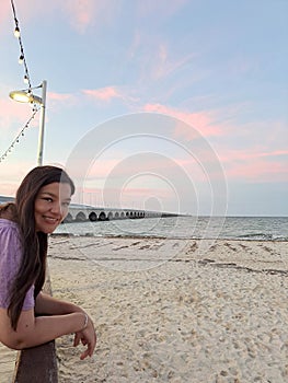 Latin adult woman walks along the boardwalk of Puerto Progreso in Yucatan, Mexico, enjoys the sunset on her vacation photo