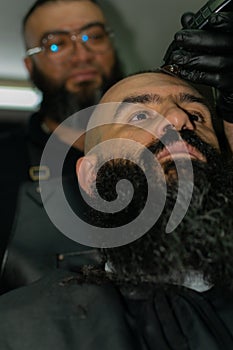Latin American barber working the style with a long beard in the city of Bogot photo