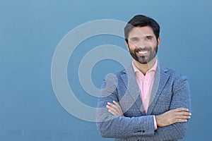 Latin American business man isolated on blue background with copy space crossing his arms and smiling