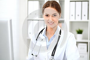 Latin american doctor woman standing with arms crossed and smiling at hospital. Physician ready to examine patient