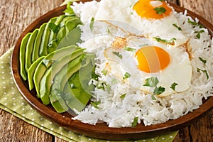 Latin American food of boiled rice and fried eggs close-up in a plate. horizontal photo