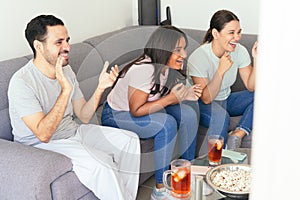 Latin American friends watching sports on television at home