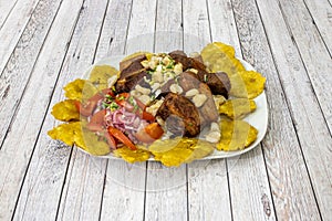 Latin American fry of pork, fried patacon, corn with parsley and tomato salad