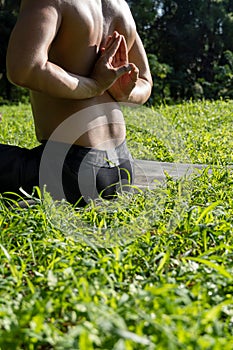 Latin American man doing yoga posture on the grasses