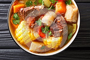 Latin American Sancocho thick meat soup with vegetables close-up on a plate on the table. horizontal top view photo