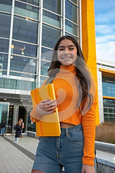 Latin american student smiling with notebook on college campus, portraying cheerful demeanor photo