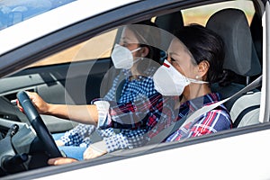 Latin American woman in face mask driving car