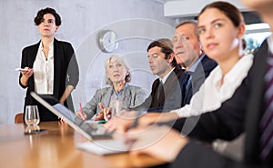 Latin American woman presenting business strategy to partners in office