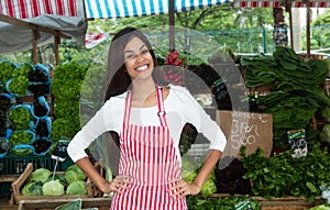 Latin american woman selling vegetables and salad at farmers mar photo