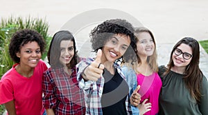 Latin american woman showing thumb with group of girlfriends