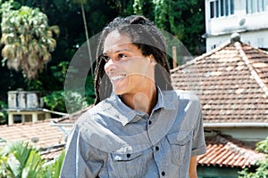 Latin american young adult man with dreadlocks looking sideways