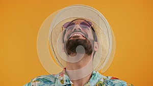 Latin bearded grateful handsome man wearing a holiday hat and a pair of sunglasses with blue lenses. Studio close up