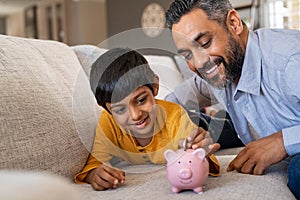 Latin boy saving money in piggybank