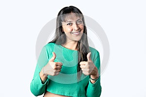 Latin brunette woman smiling doing thumbs up and looking at camera