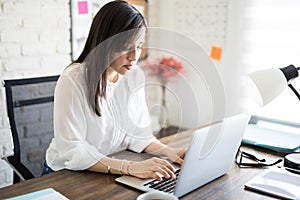 Latin businesswoman working at her desk