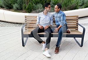 Latin couple gay men sitting on a bench, gay concept