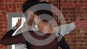 Latin dances - man and woman training their dance in the studio with brick walls